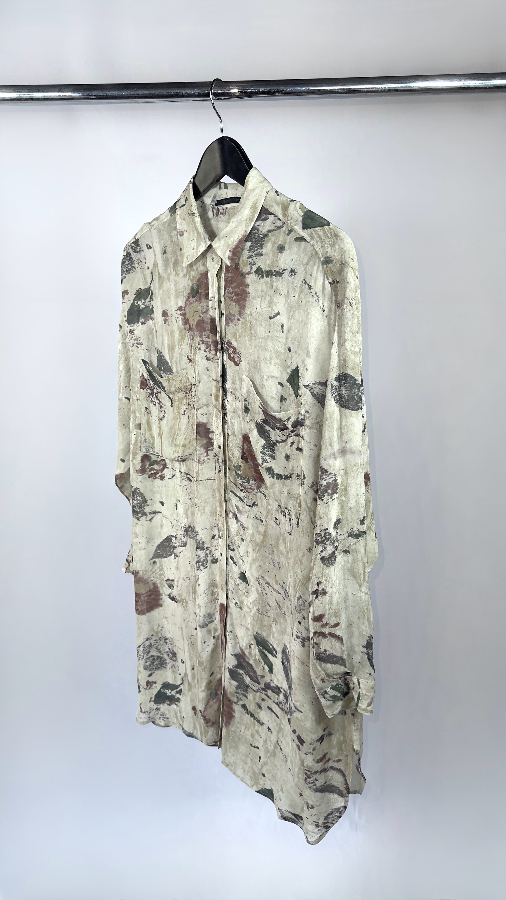 Floral patterned shirt on a hanger against a white background