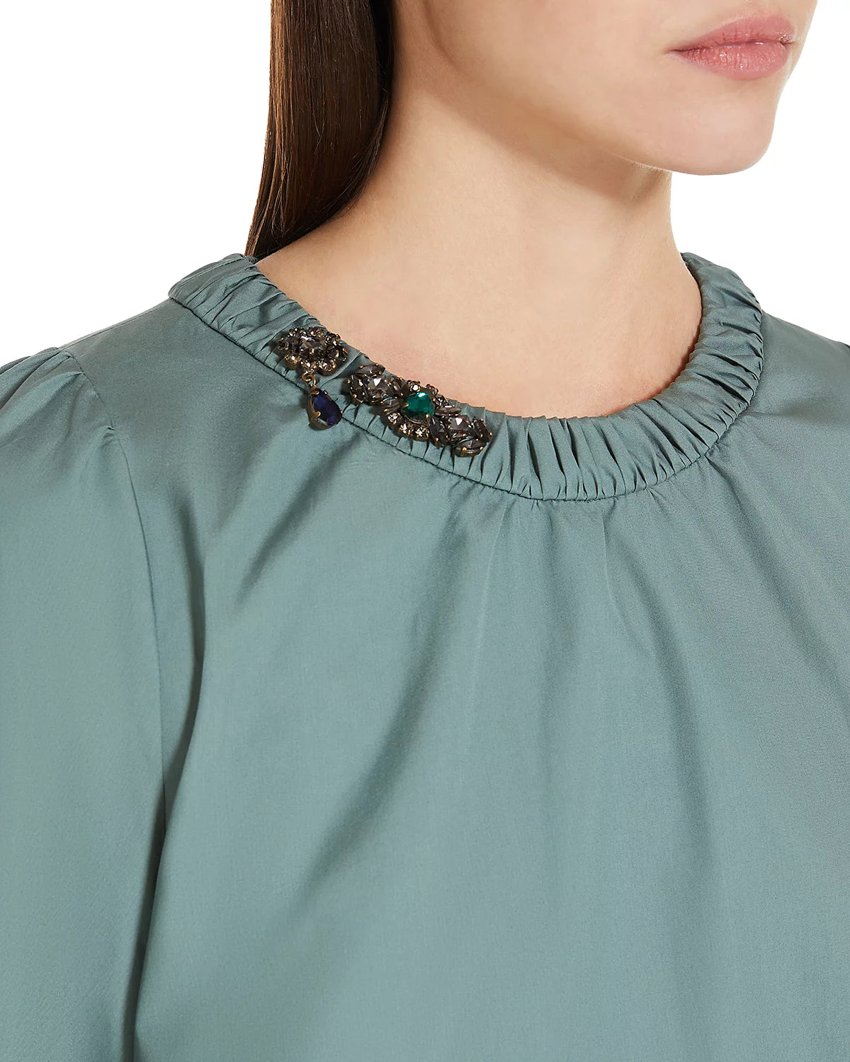 Close-up of a green blouse with embellished neckline