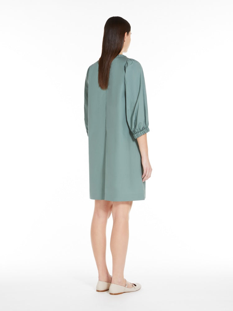 Woman wearing a light green dress on a white background