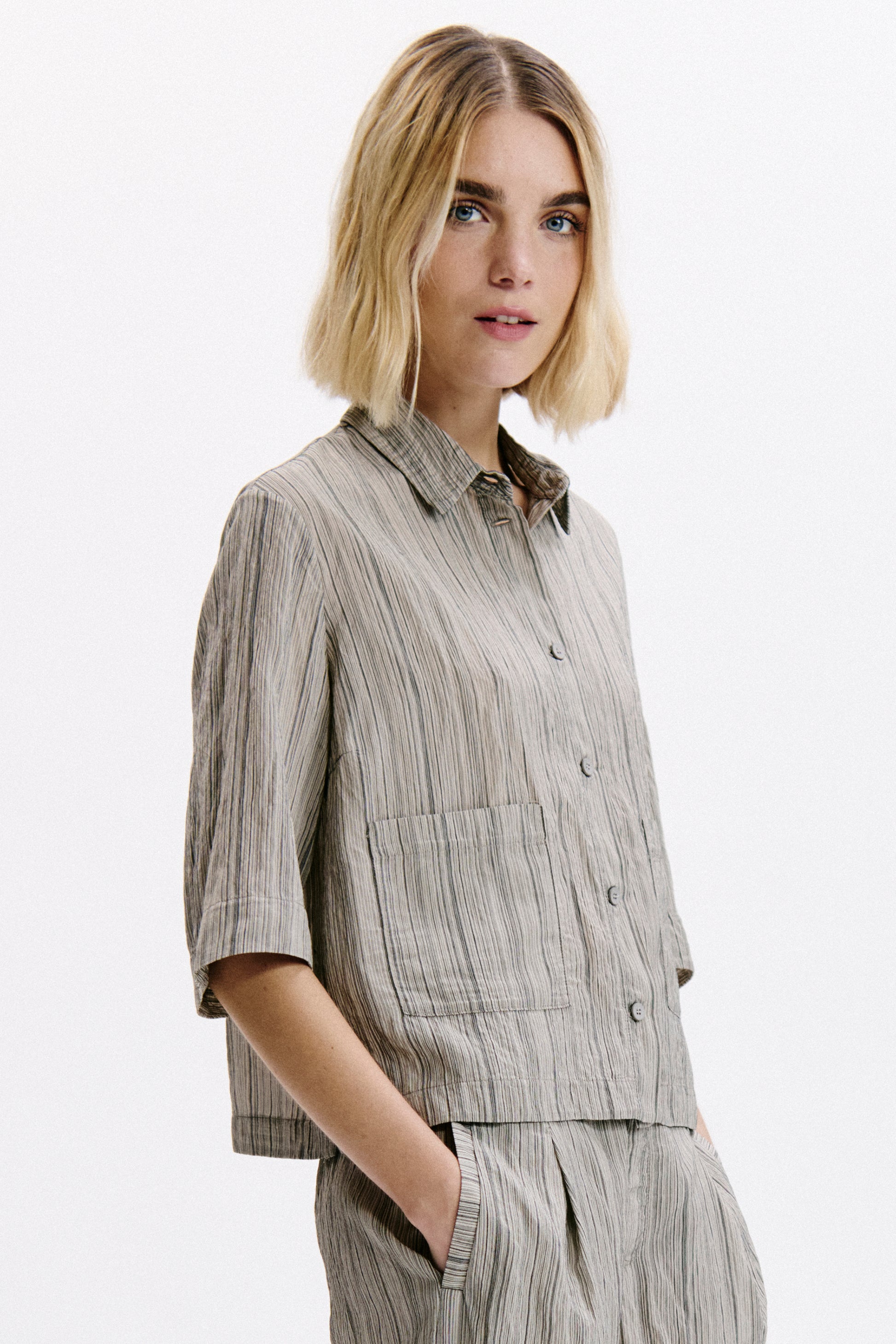 Woman wearing a striped shirt and pants on a white background