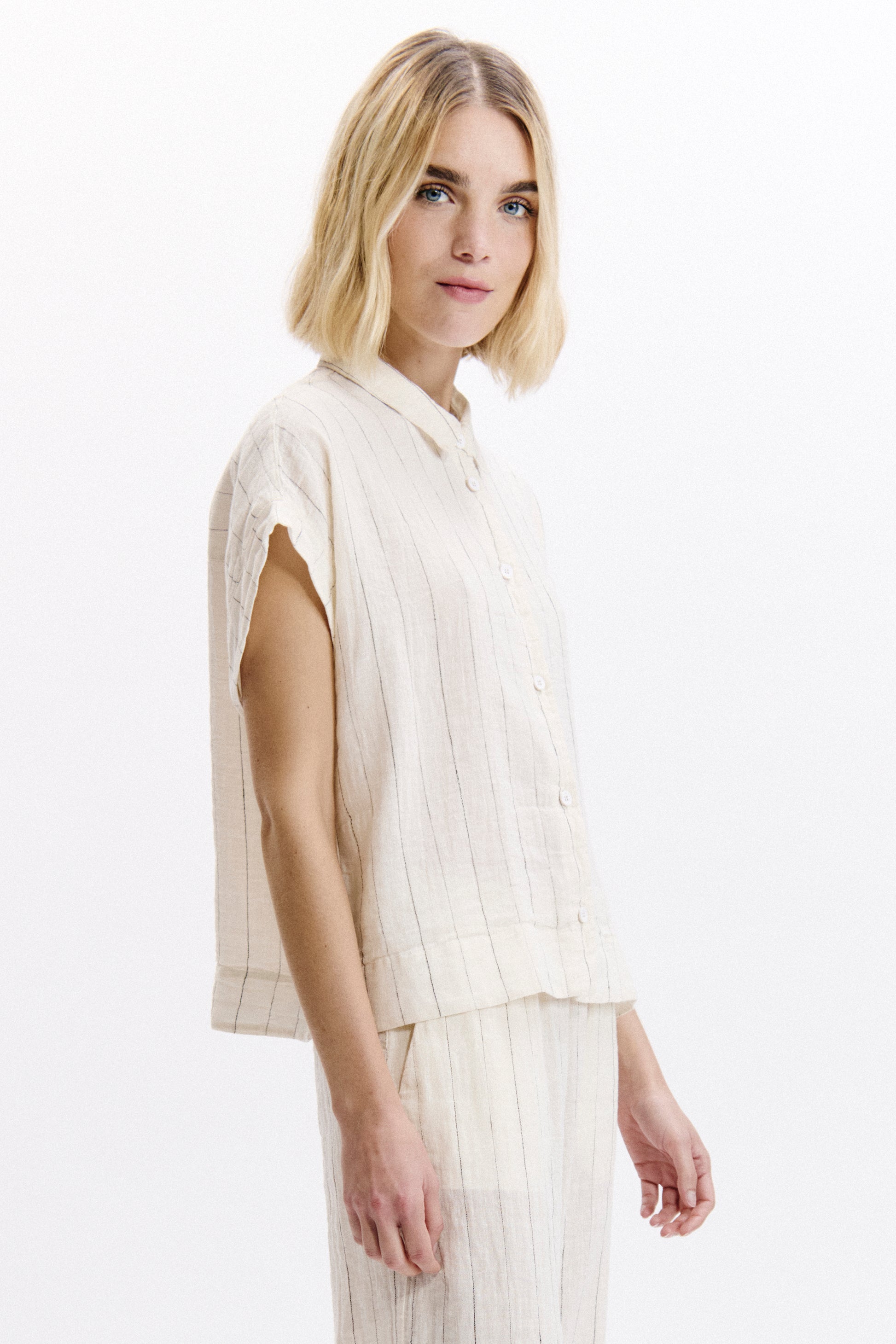 Woman wearing a light-colored outfit on a white background