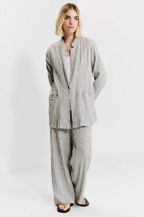 Person wearing a gray checkered suit on a white background