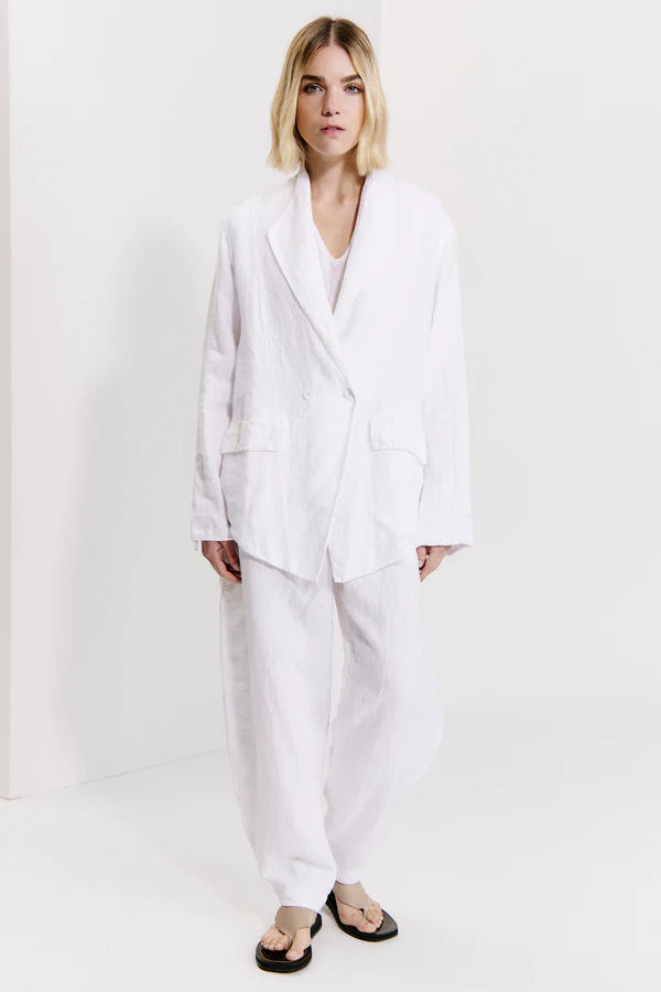 Person wearing a white suit on a plain background