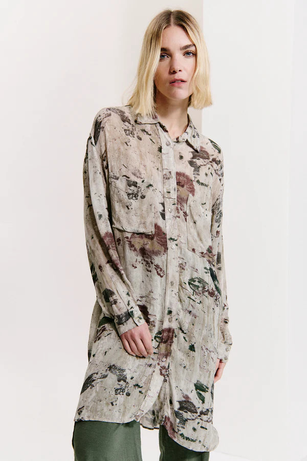 Woman wearing a floral patterned shirt against a white background