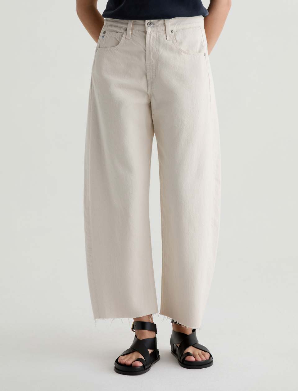 Person wearing beige wide-leg pants on a white background