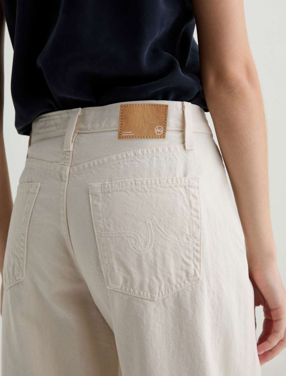 Beige pants with a brown patch on the back pocket against a neutral background