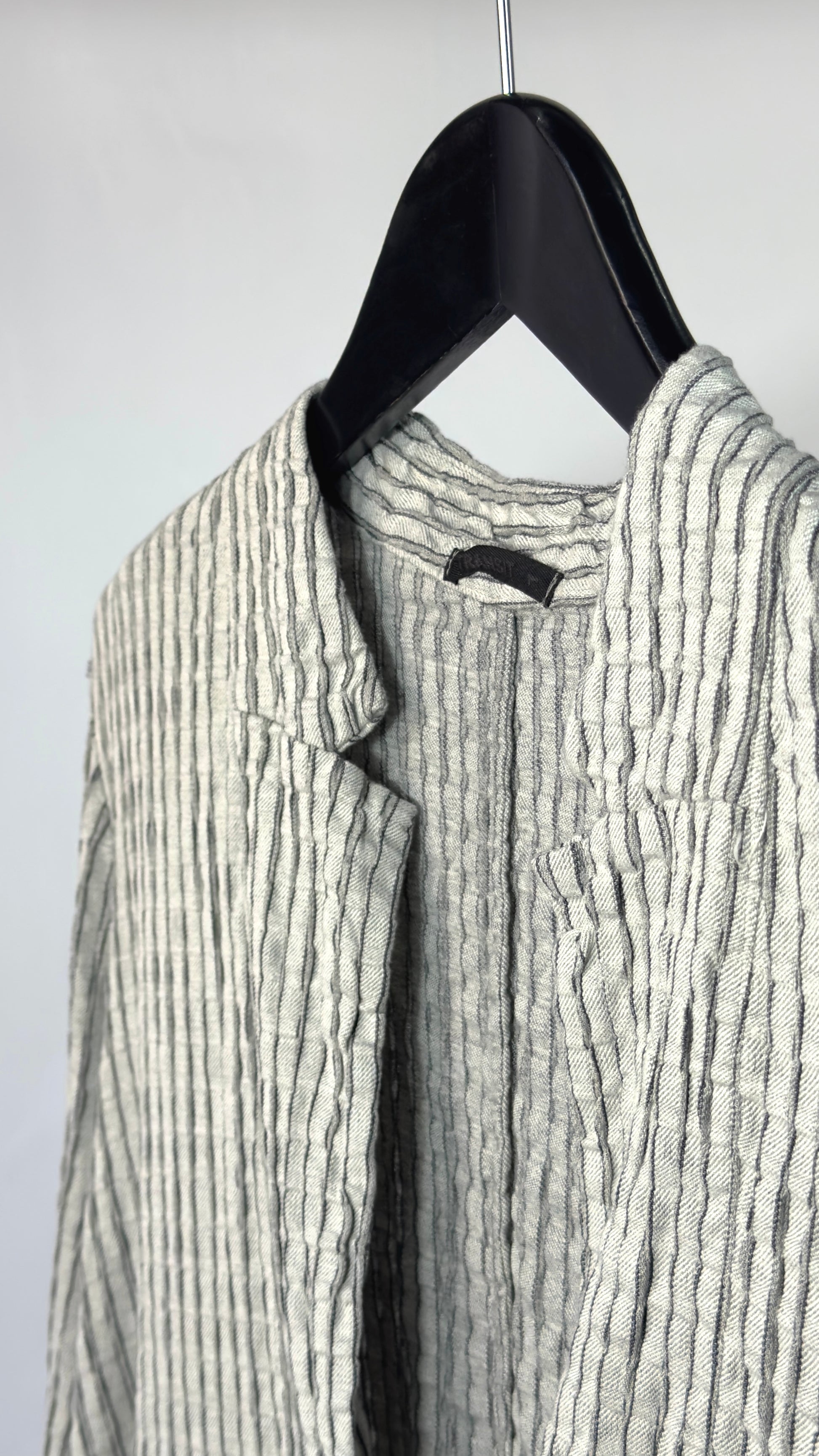 Striped jacket on a hanger against a plain background