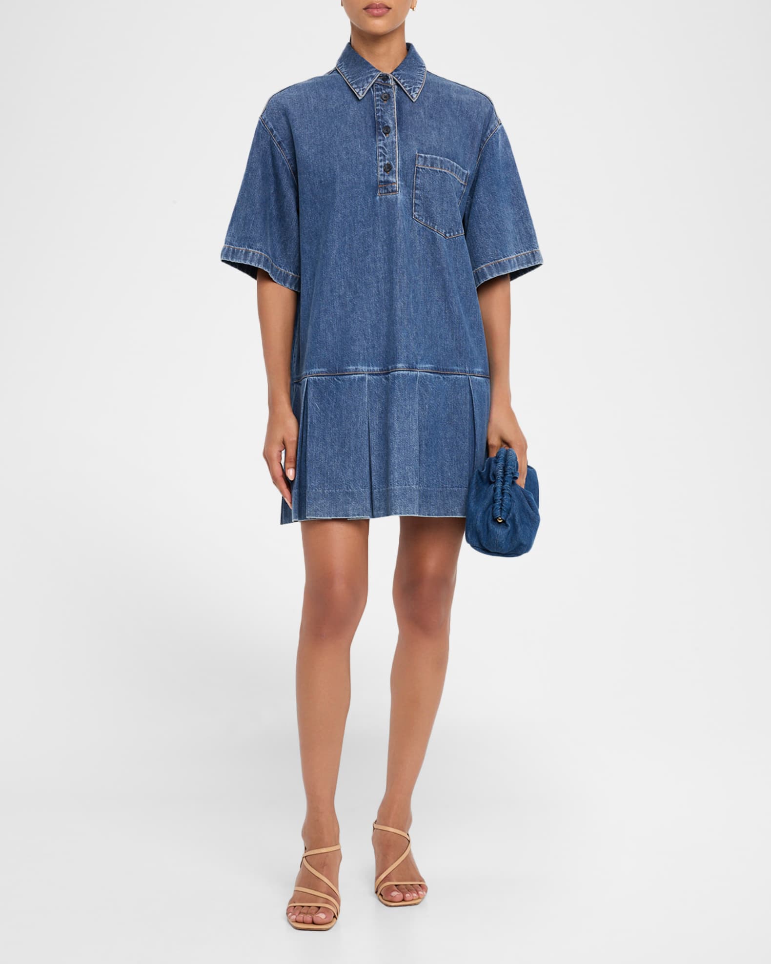 Woman wearing a blue denim dress on a white background
