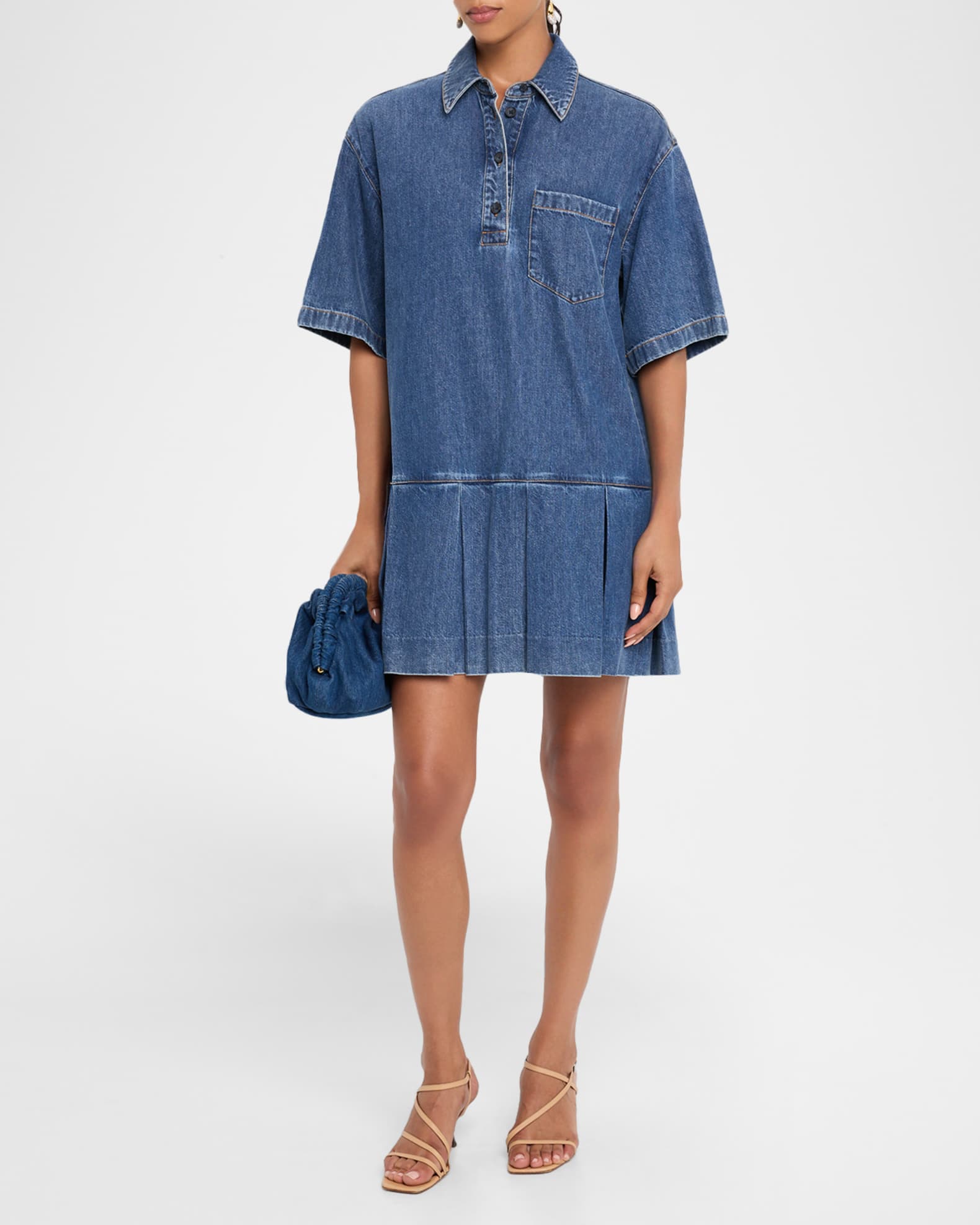 Person wearing a blue denim dress on a white background
