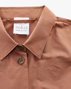 Brown shirt collar with 'roka' label on a white background