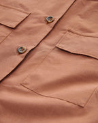 Close-up of a brown shirt with buttons and pockets