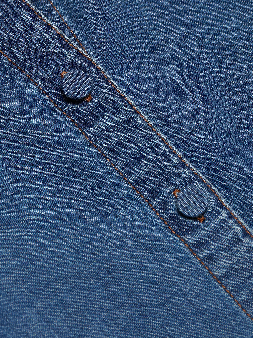 Close-up of blue denim fabric with stitching details