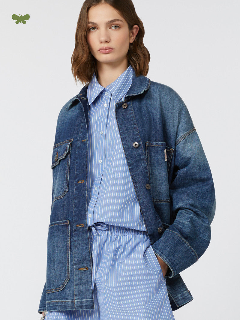 Woman wearing a blue denim jacket over a striped shirt on a white background