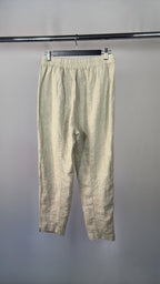 Beige pants hanging on a rack against a gray background