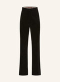 A pair of black velvet high-waisted pants with a slightly flared leg, closed with button, hook and zip, and side pockets.