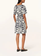 Woman wearing a black and white floral dress on a white background