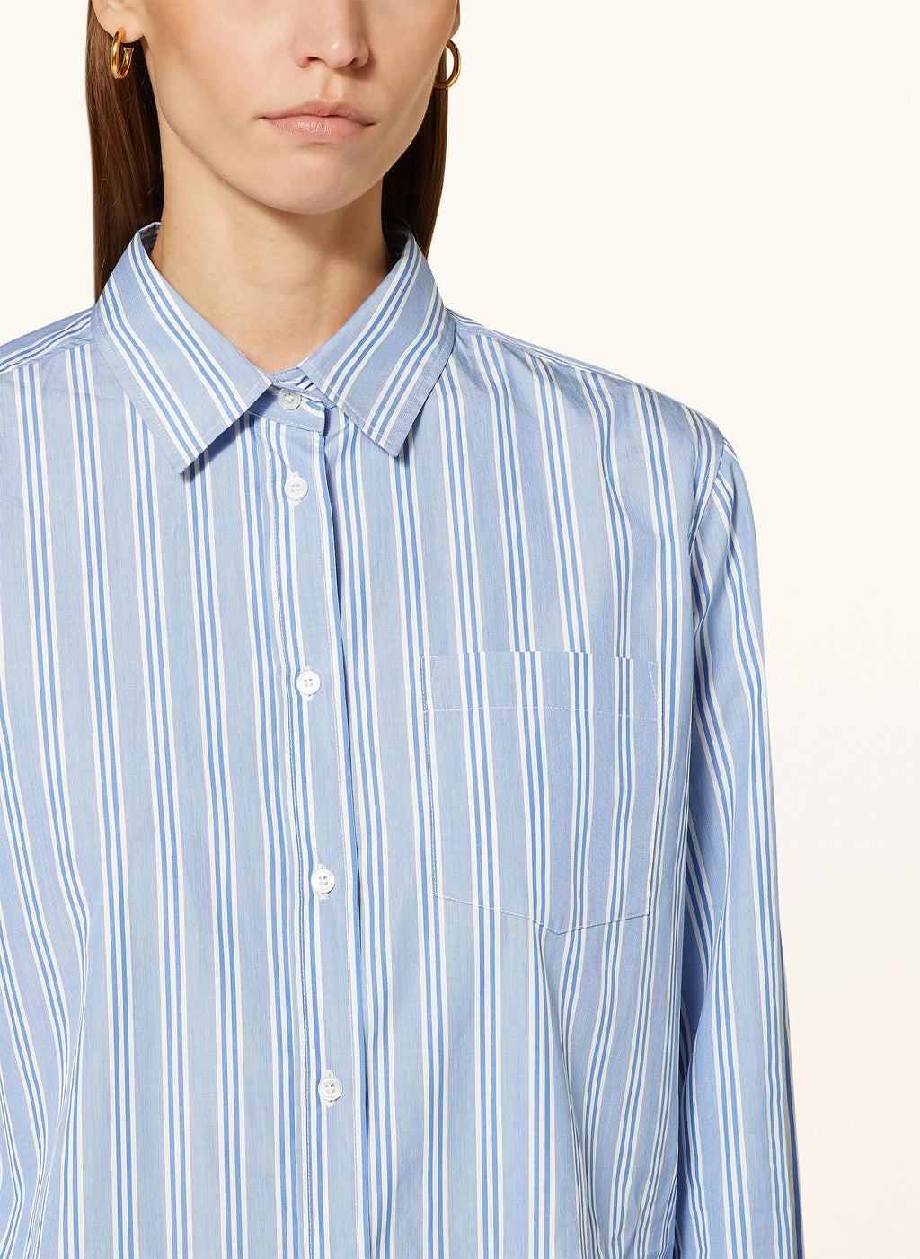 Blue striped shirt worn by a person on a white background