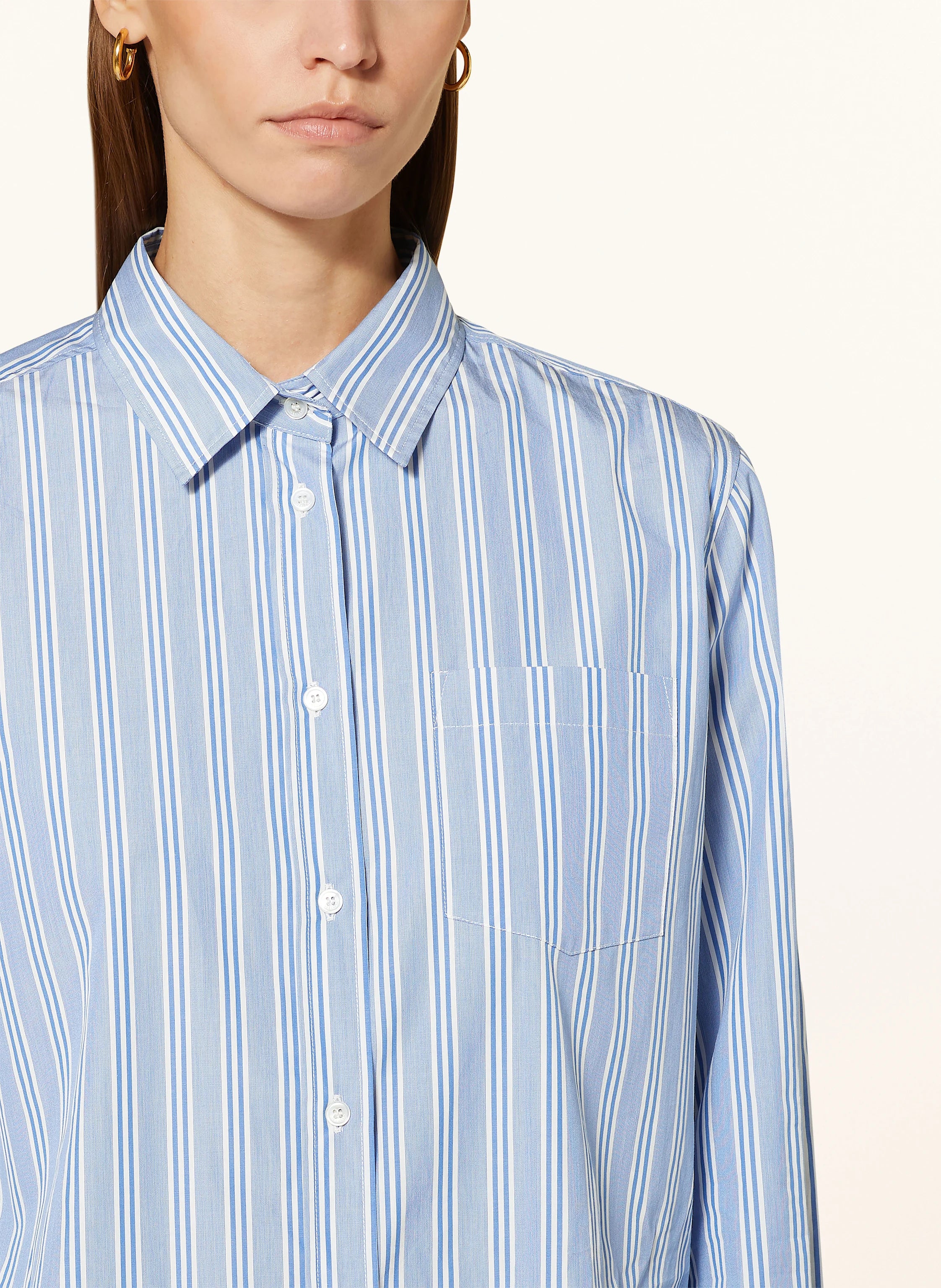 Blue striped shirt worn by a person on a white background