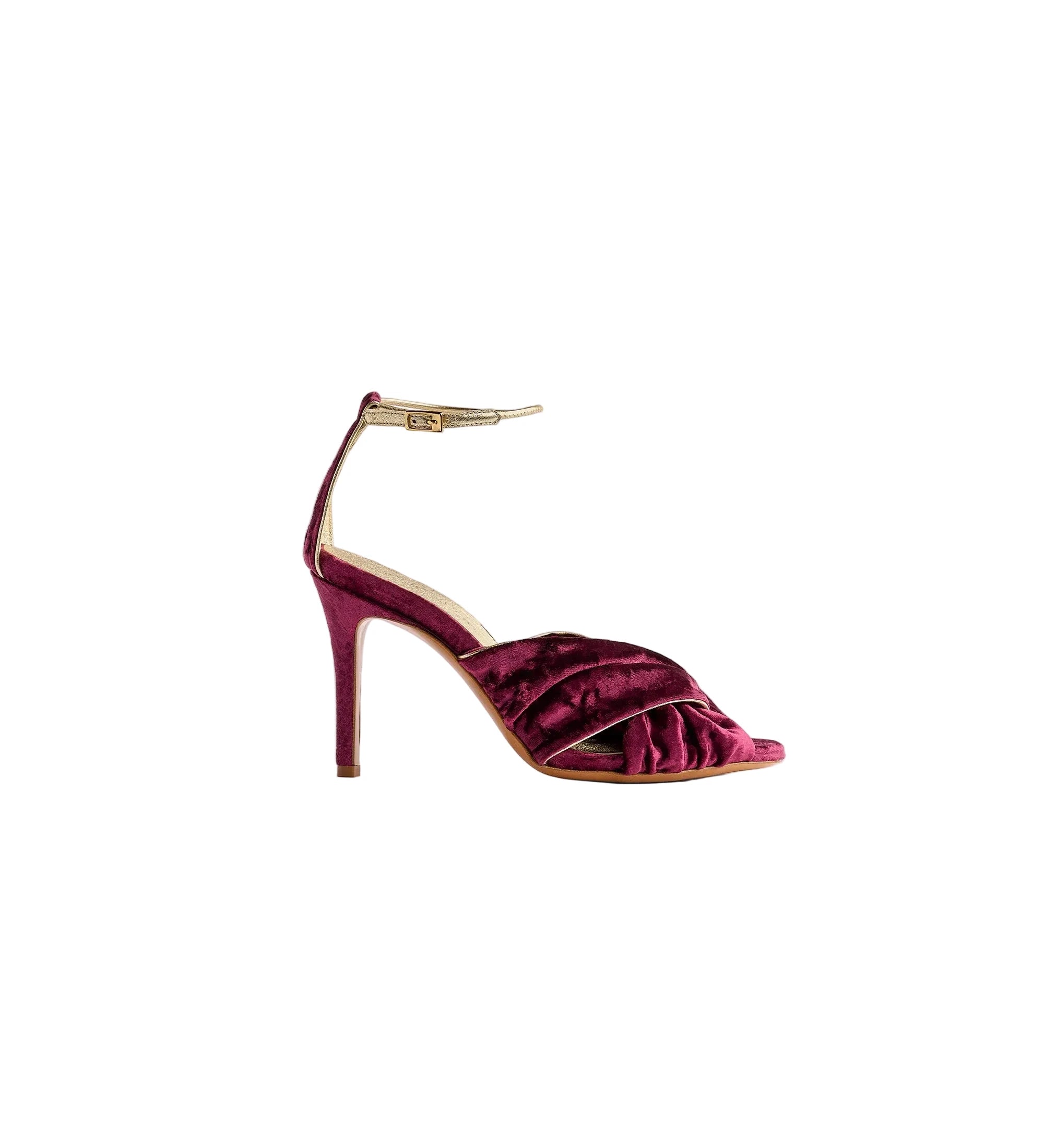 Purple high-heeled shoe with a gold buckle on a white background