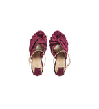 A pair of women's velvet sandals in a deep burgundy/magenta color, featuring a knotted criss-cross strap design and thin tan ankle straps, shown from a top-down view on a light gray background.