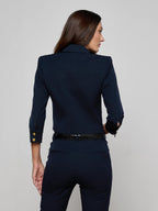 Woman wearing a navy blue suit with a plain background