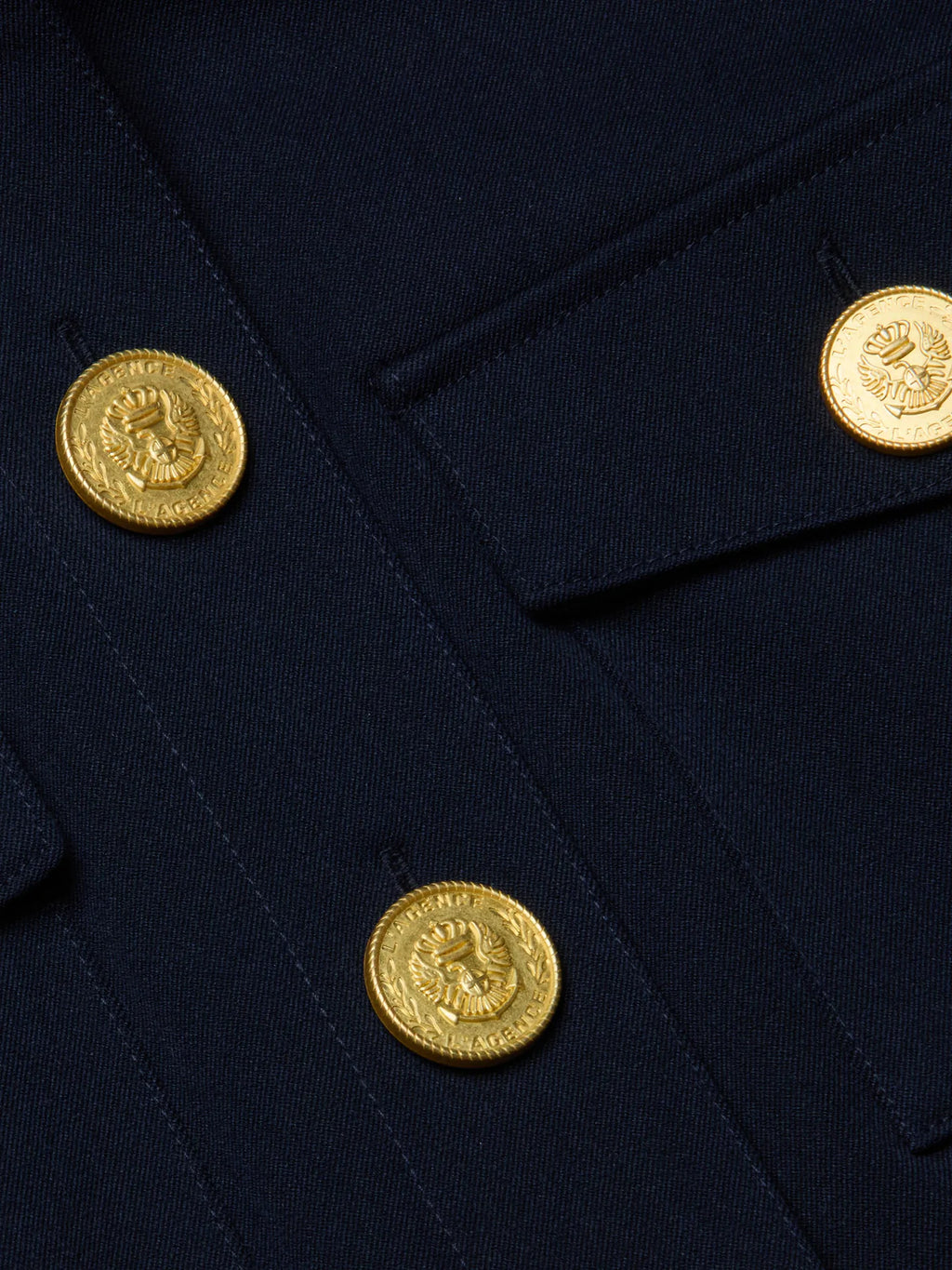 Close-up of a navy blue fabric with gold buttons