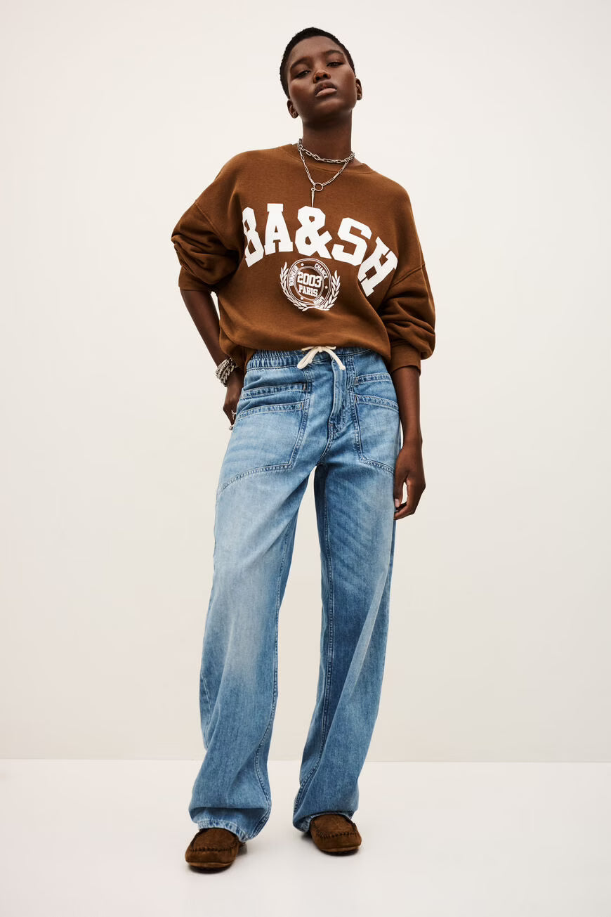 The MIMA jeans by ba&sh are an ode to casual style. These trousers have a loose fit, complemented by an elasticated waistband with a rope drawstring. The denim is soft and comfortable to wear. These jeans also have double front pockets. Wear with a t-shirt or jumper and a pair of trainers. To elevate the look, you can roll up the cuffs.

