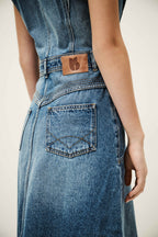 Blue denim dress with a brand logo on the back pocket against a neutral background