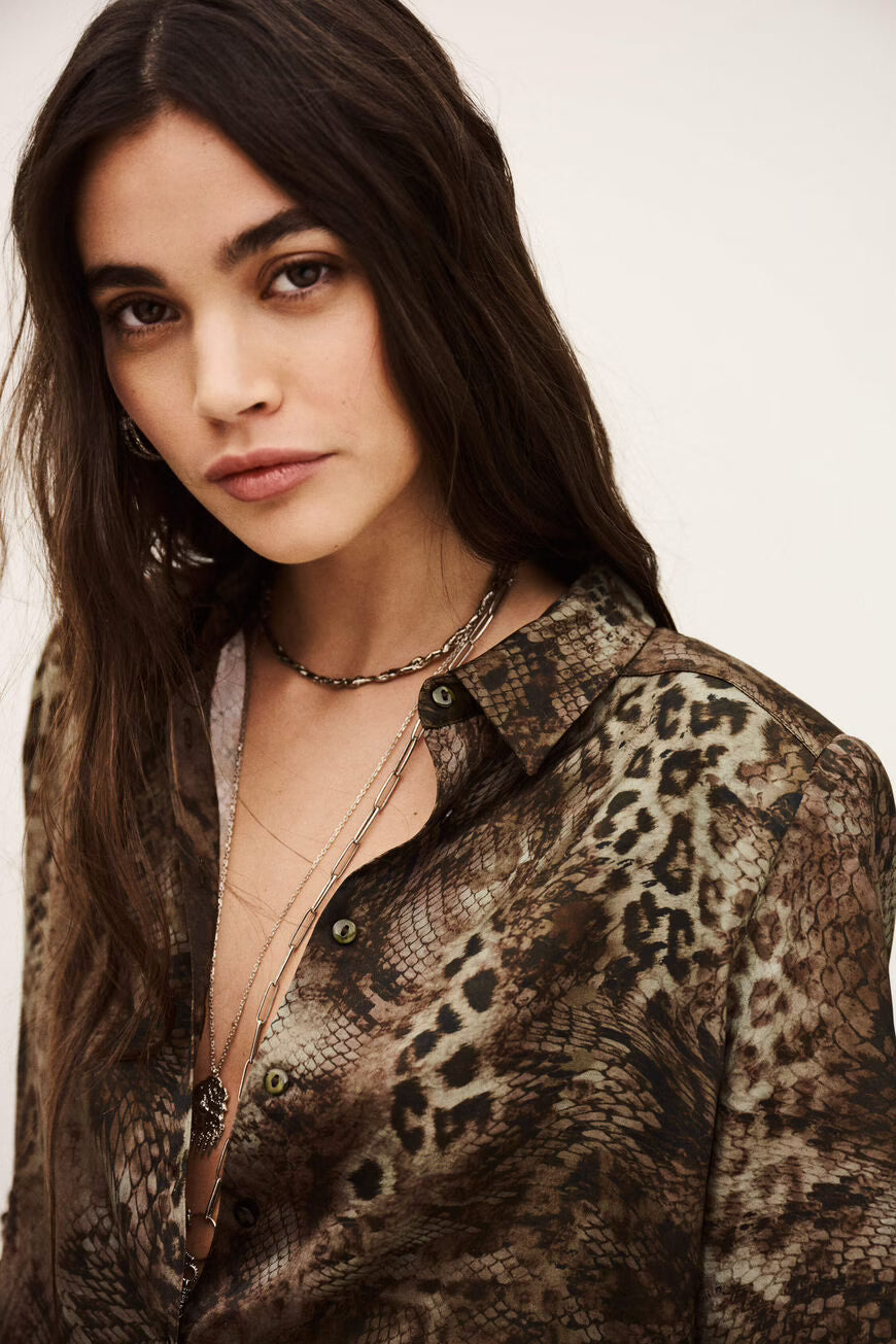 Woman wearing a patterned shirt with a neutral background