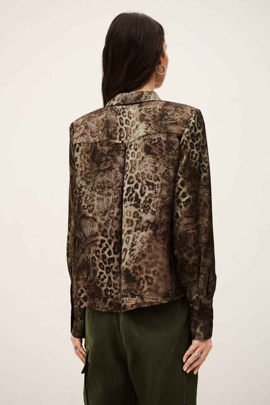 Person wearing a patterned shirt with a neutral background