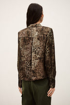 Person wearing a patterned shirt with a neutral background