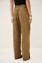 Brown pants worn by a person on a plain background