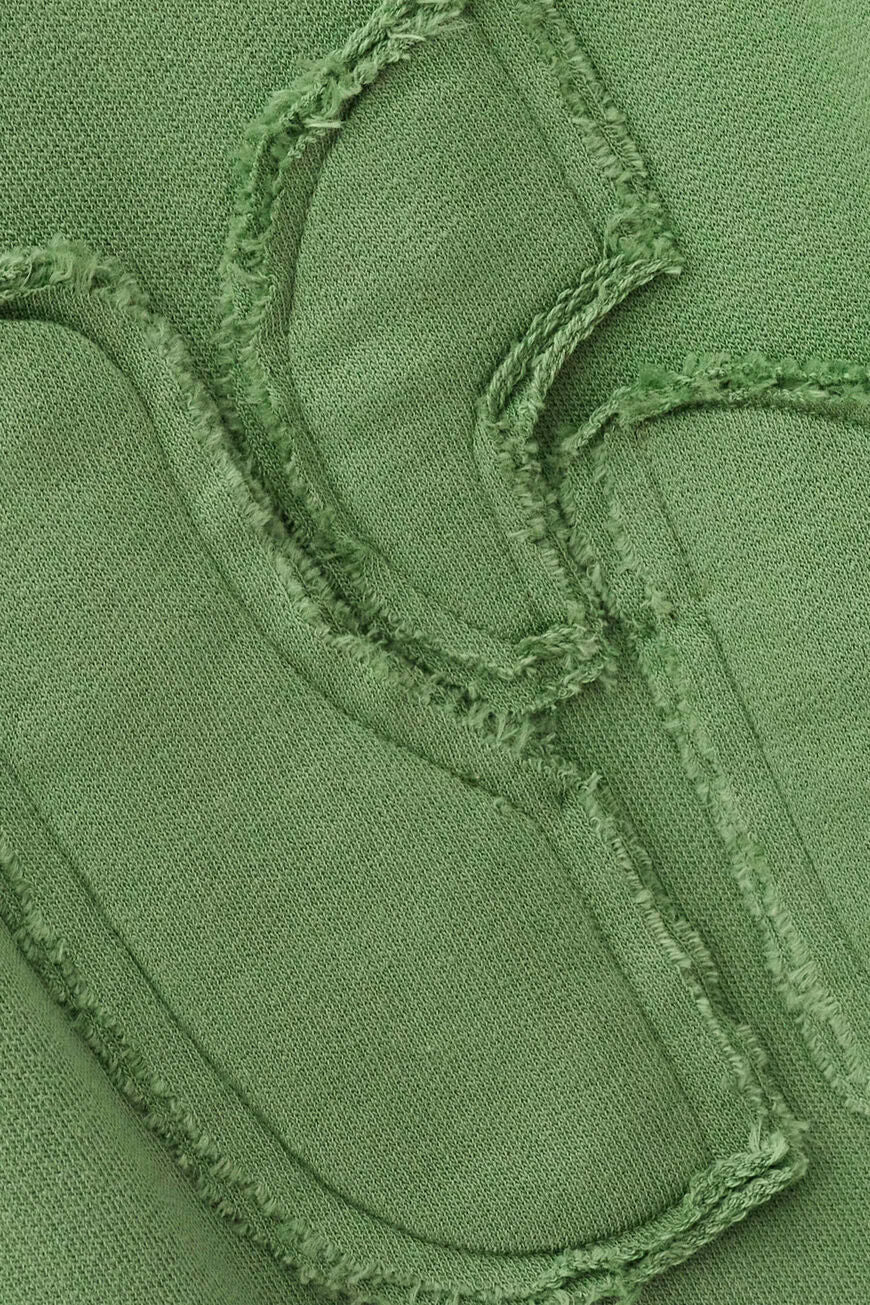 Close-up of green fabric with textured stitching