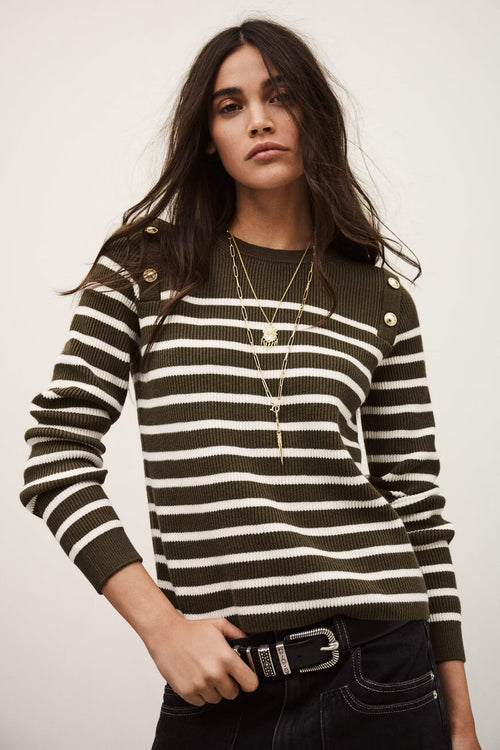 Woman wearing a black and white striped sweater with a plain background