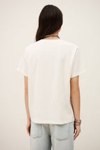Person wearing a white top and light blue jeans on a plain background
