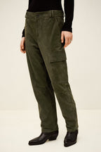 Person wearing olive green cargo pants on a white background