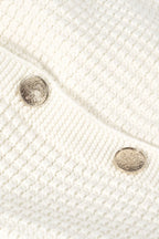 Close-up of a textured white fabric with two buttons.
