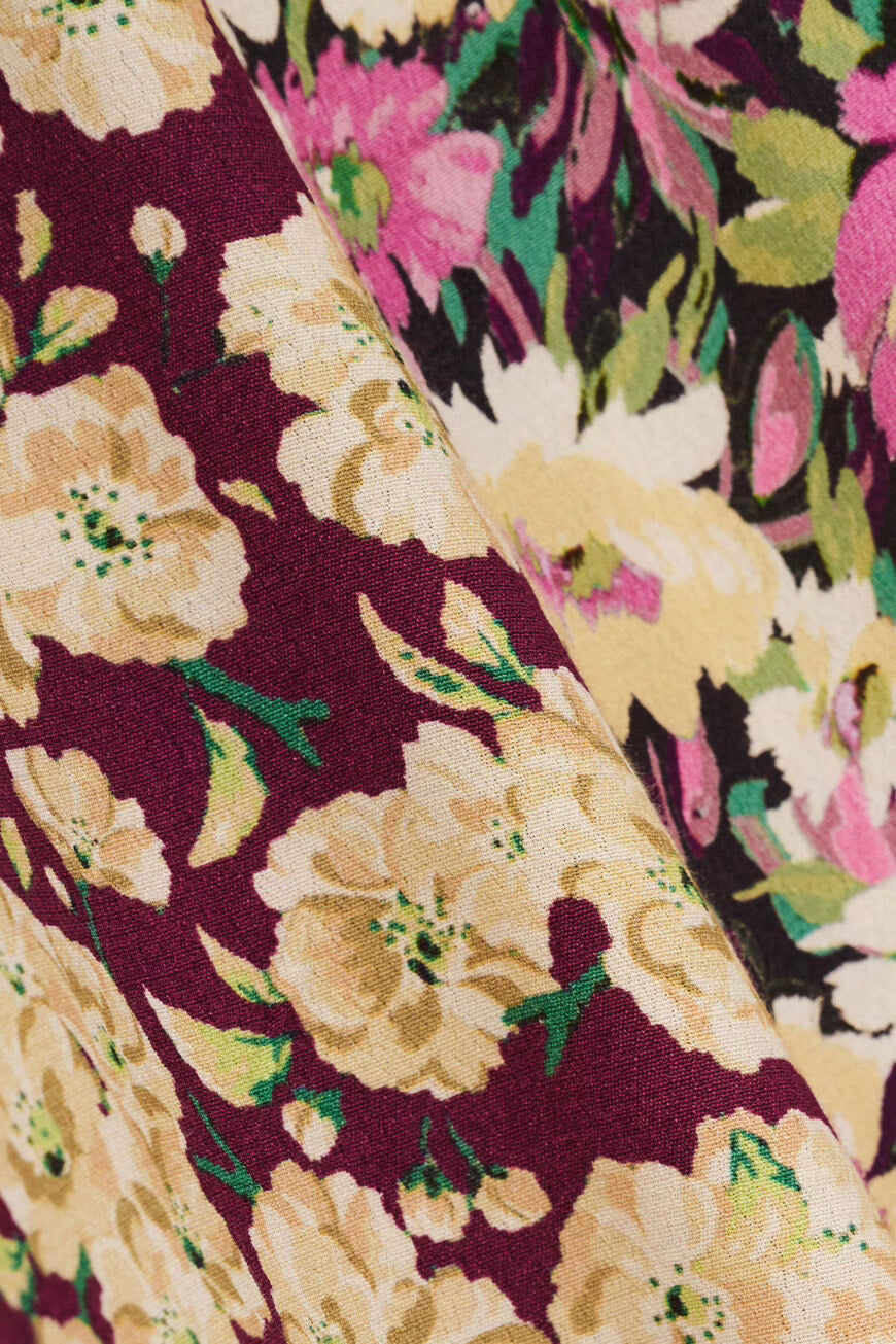 Close-up of a floral fabric pattern with beige flowers on a dark background