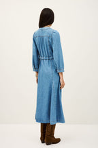 Woman wearing a blue denim dress on a white background