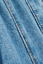 Close-up of blue denim fabric with yellow stitching