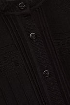Close-up of a black textured fabric with buttons
