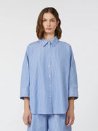 Woman wearing a blue striped shirt and pants on a white background