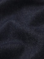 Close-up of dark navy blue textured fabric with a fine woven pattern and soft folds.