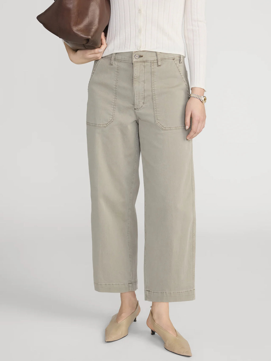 Person wearing beige high-waisted pants on a white background