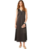 Woman wearing a black slip dress with lace detailing on a white background