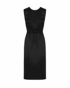 A black sheath dress with a crew neck, gathered waist, V-neckline, and pleat on the back. There is a visible zip opening on the side.