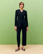 A model wearing black straight twill trousers with an elastic waistband, side pockets, and a crew neckline.