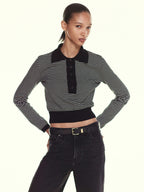 Woman wearing a FRAME  black and white striped shirt with a black collar and black pants on a white background. SHOP ONLINE