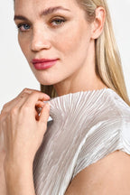 Close-up of a woman wearing a rich and royal  silver pleated top against a white background shop online muse boutique hawthorn