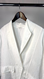 White linen shirt on a hanger against a gray background